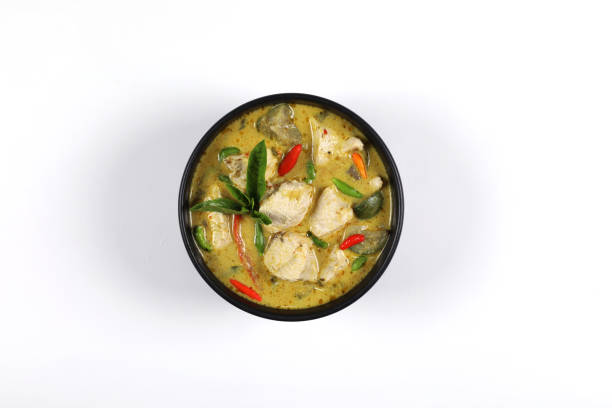 Thai food, Green curry chicken in a black bowl Isolated on white background, top view have copy space. Thai food. Chicken green curry put in a black bowl isolated on white background. chicken breast, coconut milk, brinjal, curry paste, basil, kaffir lime leaves, garden paprika. Top view have copy space. chicken curry stock pictures, royalty-free photos & images