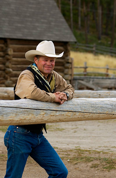 Cowboy Leans on Fence stock photo