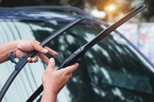 Mechanic replace windshield wipers on car. Replacing wiper blades