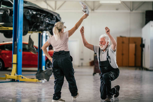Cheerful auto mechanic havig fan after work