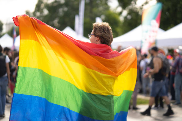 Gay man holding large pride flag stock photo