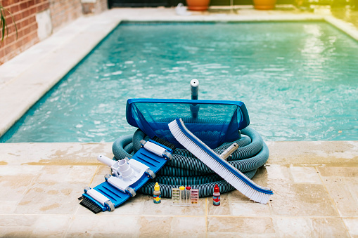 Image of pool cleaning and maintenance kit, vacuum cleaner, ph test, leaf picker and pool sweeper, Pool cleaning and maintenance tools