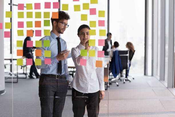 istock Confident Indian mentor woman teaching young Intern guy 1398758248