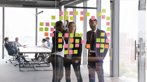 istock Confident coach teaching employees, training to use Kanban board 1398758257