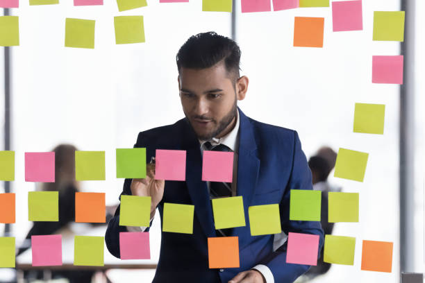 istock Positive engaged millennial business leader man writing notes 1398758293