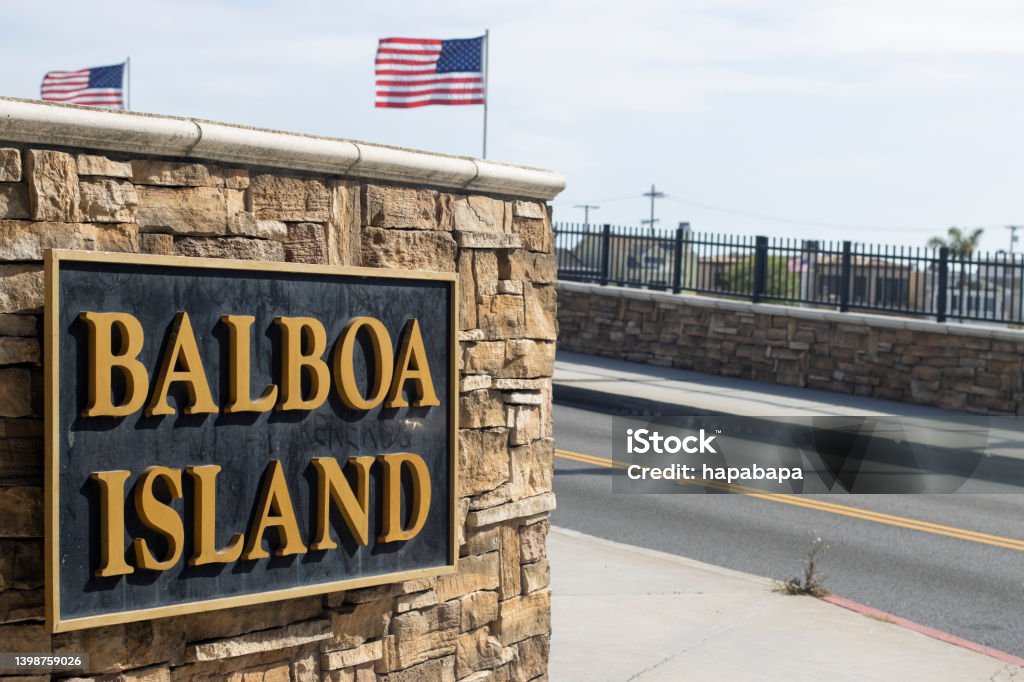 Balboa Island Closeup of the Balboa Island sign on the Balboa Island channel bridge in Newport Beach, California. American Flag Stock Photo