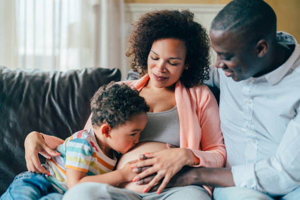 Pregnant woman with husband and son at home stock photo