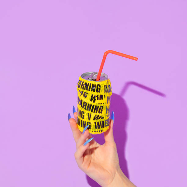 Summer creative layout with woman hand with long nails holding soda can wrapped in warning packing tape  on pastel purple background. 80s or 90s retro fashion aesthetic drink  concept. Minimal summer pop art idea.