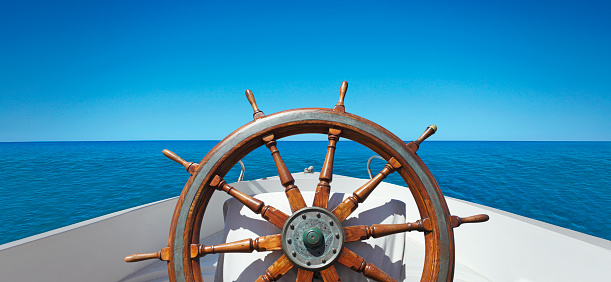 Panoramic view of wooden ship's wheel on the boat at the ocean