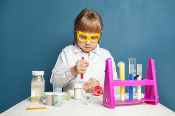 istock Child school student conducting science experiments in classroom. 1398760764