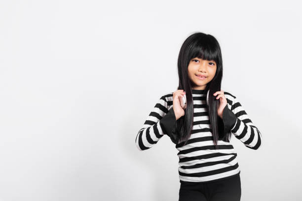 azjatyckie dziecko w wieku 10 lat uśmiechnięte słuchając muzyki w bezprzewodowym zestawie słuchawkowym na szyi - 8 9 years audio zdjęcia i obrazy z banku zdjęć