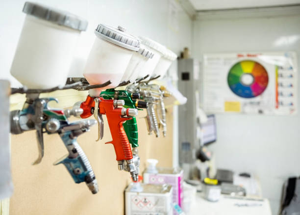 Set of automobile paint spray guns hanging on rack Set of paint spray guns hanging on rack at service station Spray Paint Colors stock pictures, royalty-free photos & images