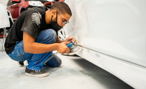 mecânico lixando painel roqueiro de um carro em oficina - car auto repair shop repairing accident - fotografias e filmes do acervo