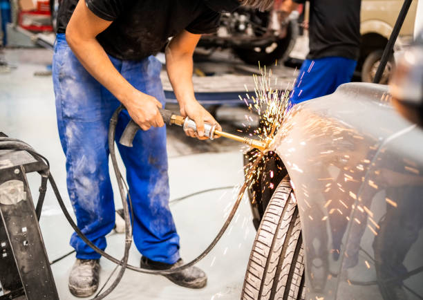 mechaniker peening auto mit werkzeug zum entfernen von dellen - karosserie stock-fotos und bilder