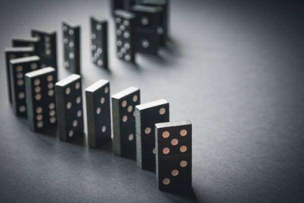 istock Black dominoes chain on table background 1398763204