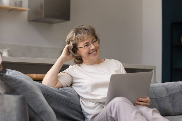 istock Addicted to modern technology dreamy mature woman using computer. 1398764300
