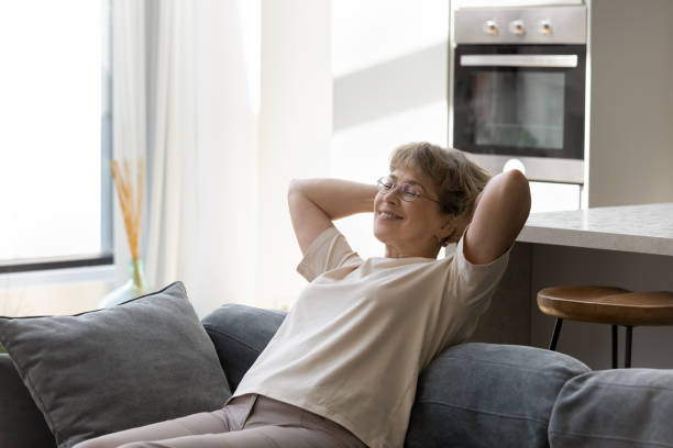 istock Happy peaceful middle aged woman resting on couch. 1398764311
