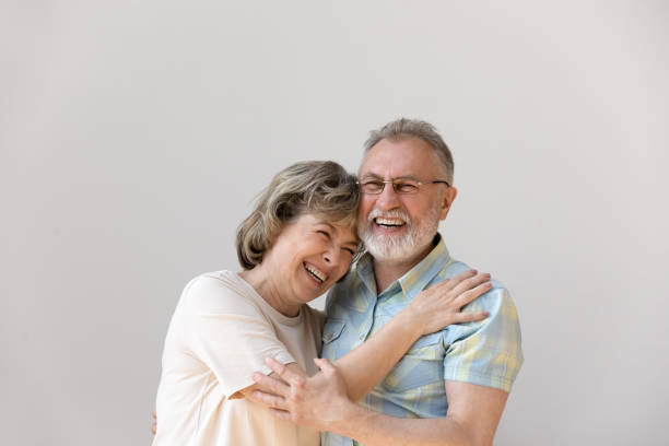 Sincere laughing bonding middle aged couple feeling happy.