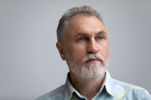 Close up head shot pensive older 60s hoary man looking in distance, feeling lonely or suffering from psychological problems, isolated on white studio background, ageing process, retired people concept
