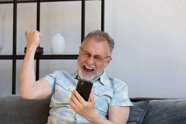istock Overjoyed laughing middle aged man celebrating online lottery win. 1398764352