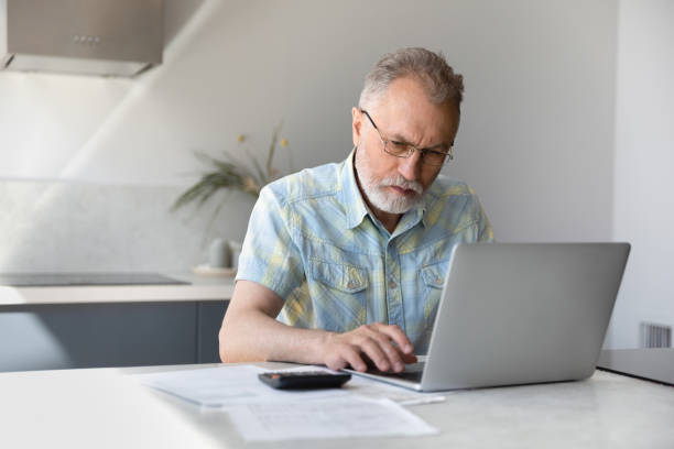 istock Focused middle aged retired man calculating budget. 1398765048