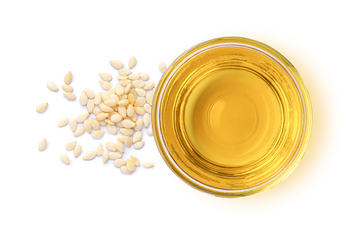 Sesame oil with seeds isolated on white background. Top view. Flat lay.