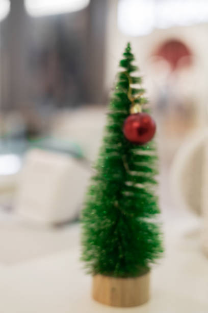 istock Christmas small green tree with a red ball. Congratulatory template. Defocused image. 1398768354