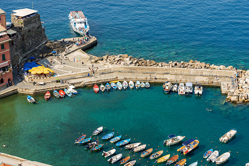 Aerial view of the small port of the ancient Vernazza village with a large group of small boats moored and the ferry station. Cinque Terre National park in Liguria, La Spezia province, Italy, Europe. UNESCO world heritage site.