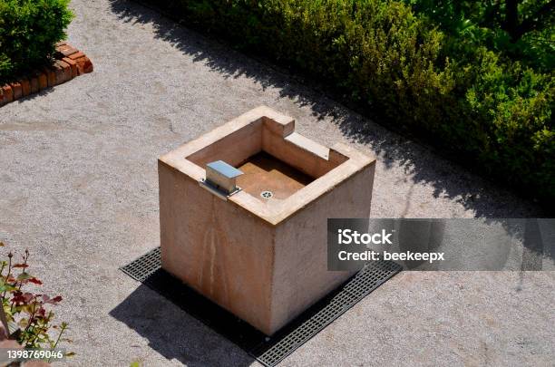 The Square Stone Fountain Serves As A Washbasin In The Park Or On The Garden Terrace People Can Wash Their Hands After A Picnic Hedges Trimmed Italian Gardens Stock Photo - Download Image Now