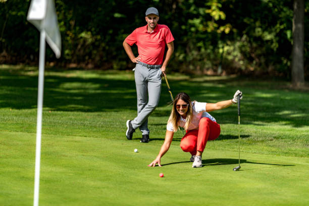 casal jogando golfe, jovem mulher lendo verde, preparando-se para putt - tee box - fotografias e filmes do acervo