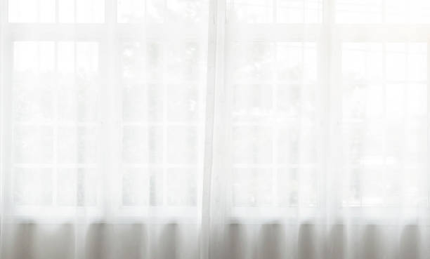 istock white curtain wavy with transparent curtain on window a pattern background. 1398771582