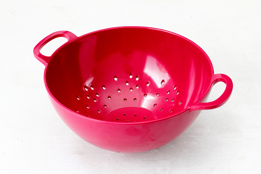 red pasta and vegetable washing strainer