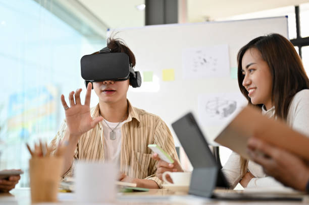 istock Millennial Asian male playing a VR game, wearing a VR headset 1398774264