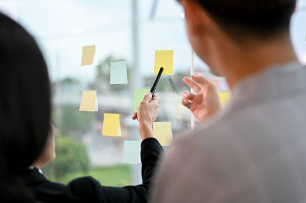 istock Close-up image, Businesspeople brainstorming, sharing their ideas on the sticky notes 1398774281