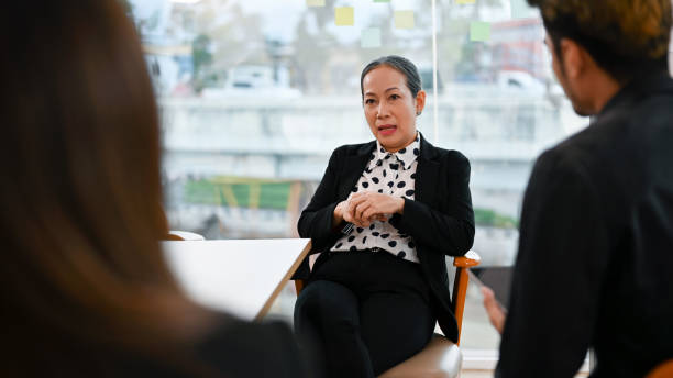 istock Aged businesswoman mentoring, coaching or complaining problems to young workers 1398774333