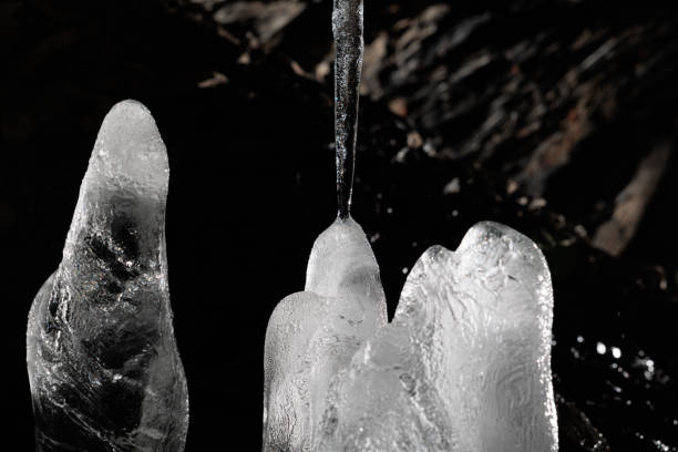 istock transparent and white ice stalagmites with dark rocky background 1398775135