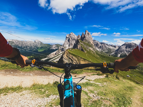 Point of view POV mountain bike on the dolomites: outdoor sport. The iconic trail by the Seceda peak in Val Gardena