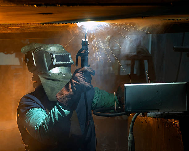 welder working welder working overhead welding helmet stock pictures, royalty-free photos & images