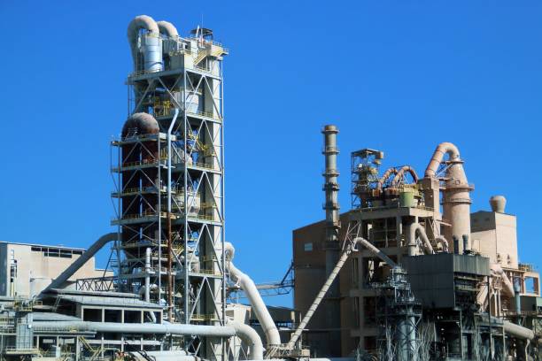 Industrial facilities of a cement plant on a sunny day. Pipes, tanks, stairs and rooms in an industrial complex in Valencia, Spain. cement work stock pictures, royalty-free photos & images