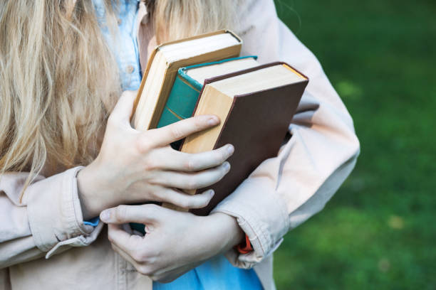 istock girl holding a stack of books in her hands 1398779860