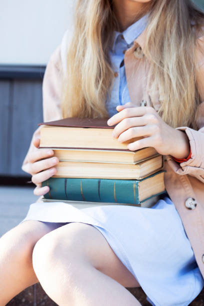 istock girl holding a stack of books in her hands 1398779876