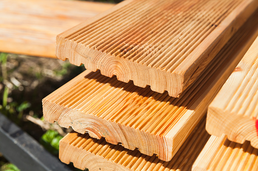 Stacked larch deck boards, close up outdoor photo