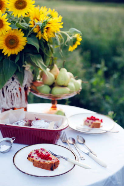 garden and still life. tea party in the garden - currant pie, vase with sunflowers and pears on a table with a white tablecloth\