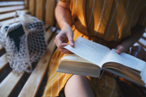 istock girl sits on a bench and reads a book 1398781499