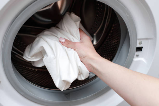 istock Put white clothes in the washing machine for washing. close-up 1398785849