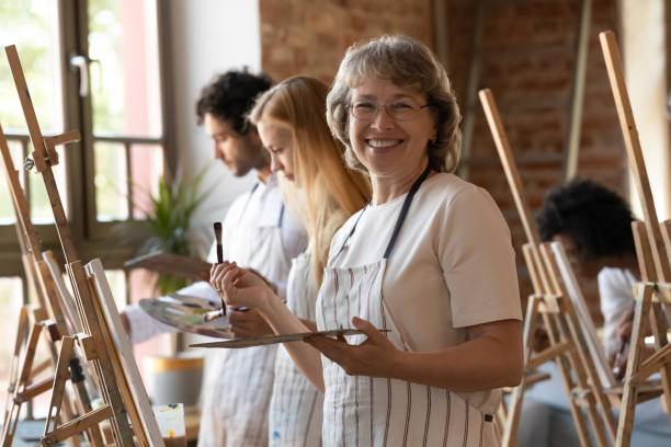 istock Happy senior retired student of art school drawing in class 1398786624