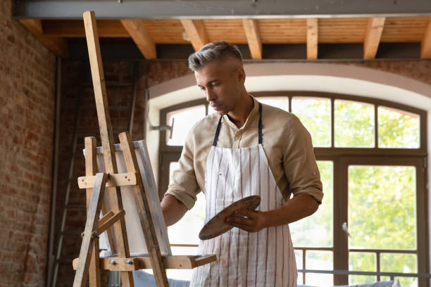 istock Serious professional artist man in craft apron working in studio 1398786634