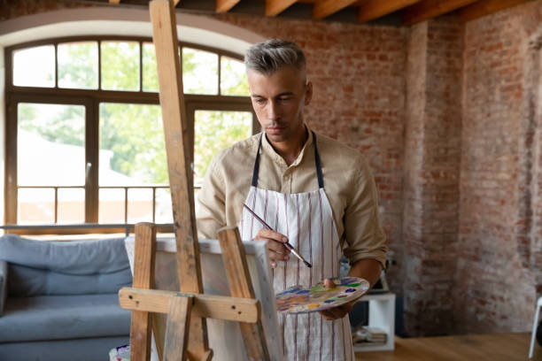 istock Pensive inspired handsome artist man drawing in paints 1398786645