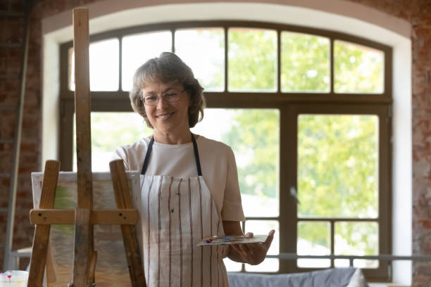 istock Happy elder retired woman enjoying creative hobby in art studio 1398786663