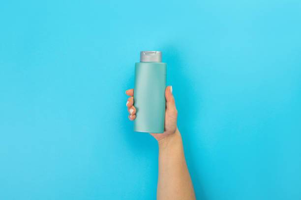 istock Housewife's hand holds a spray with cleaning agent on a blue background. Detergent for various surfaces in the kitchen, bathroom and other rooms. Close-up. Light pastel blue background. 1398786734